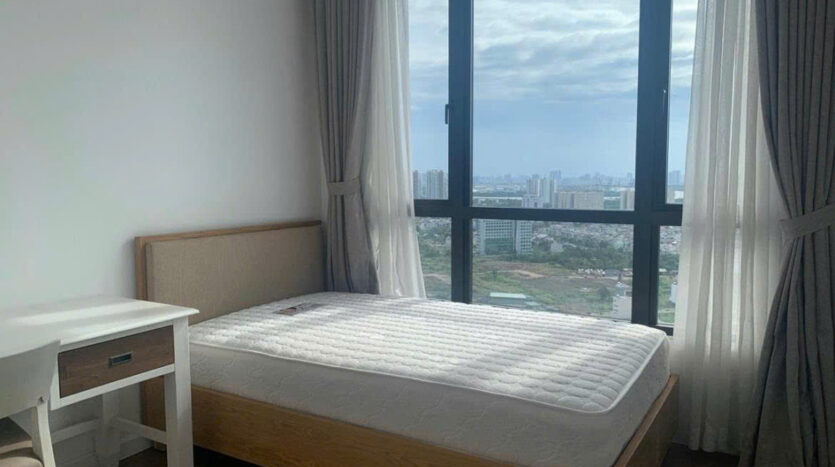 Bedroom with floor-to-ceiling window and high-rise city view at Estella Heights apartment