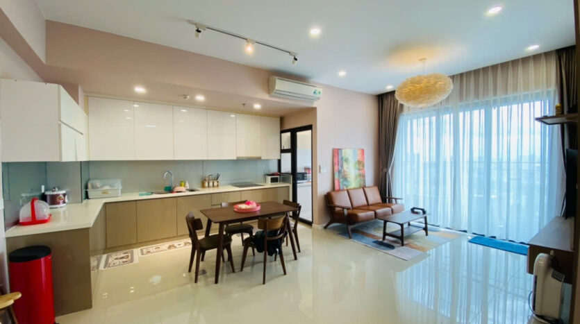Phòng khách, bếp gloss trắng và bàn ăn căn hộ Estella Heights Tower T2 với ban công kính | Living room, white gloss kitchen and dining area of Estella Heights Tower T2 apartment with glass balcony