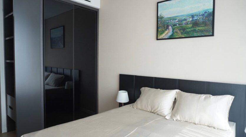 Phòng ngủ căn hộ Lumiere Riverside Tháp West với tủ đen gloss và đầu giường nhung | Bedroom of Lumiere Riverside West Tower apartment with black gloss wardrobe and velvet headboard