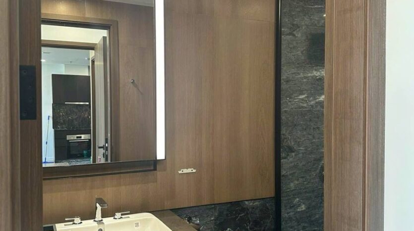 Khu vực vệ sinh phòng tắm với marble đen và gỗ óc chó căn hộ Lumiere Riverside Tháp West | Vanity area with black marble and walnut wood at Lumiere Riverside West Tower apartment