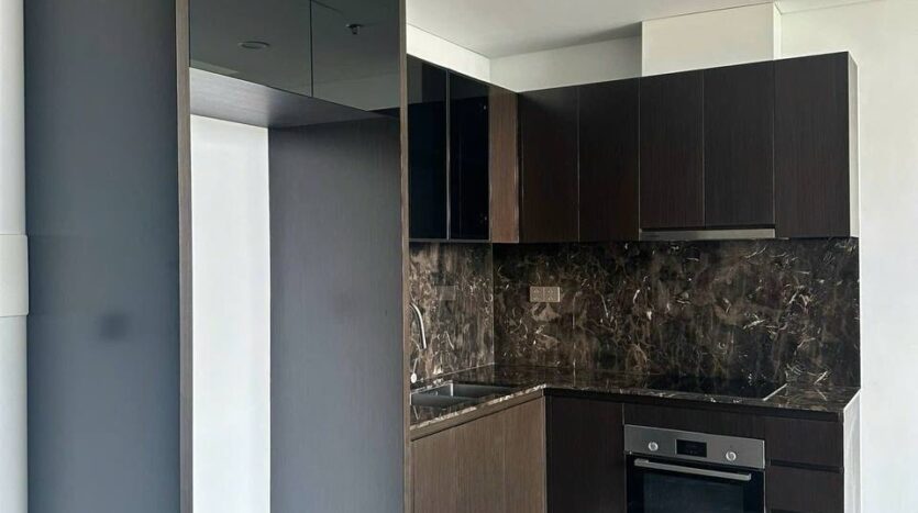 Bếp gỗ tối và marble đen built-in căn hộ Lumiere Riverside Tháp West | Built-in dark wood and black marble kitchen at Lumiere Riverside West Tower apartment