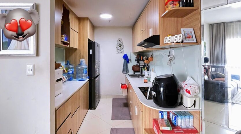 Bếp dài căn hộ Masteri Thảo Điền với tủ bếp gỗ và đầy đủ tiện nghi sinh hoạt | Galley kitchen of Masteri Thao Dien apartment with wood cabinets and full living amenities
