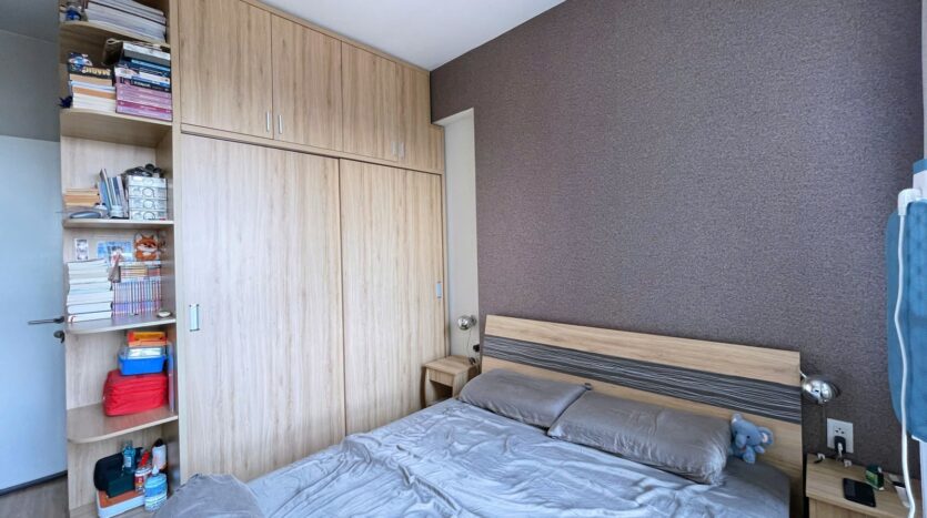 Phòng ngủ căn hộ Masteri Thảo Điền với kệ sách lớn và tủ áo gỗ | Bedroom of Masteri Thao Dien apartment with large bookshelf and wood wardrobe