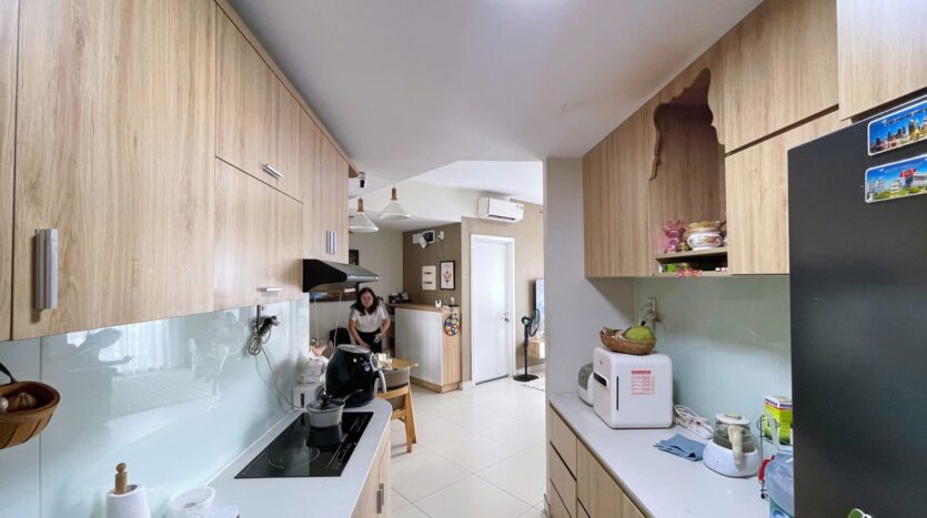 Khu bếp căn hộ Masteri Thảo Điền với tủ bếp gỗ sáng | Kitchen area of Masteri Thao Dien apartment with light wood cabinets