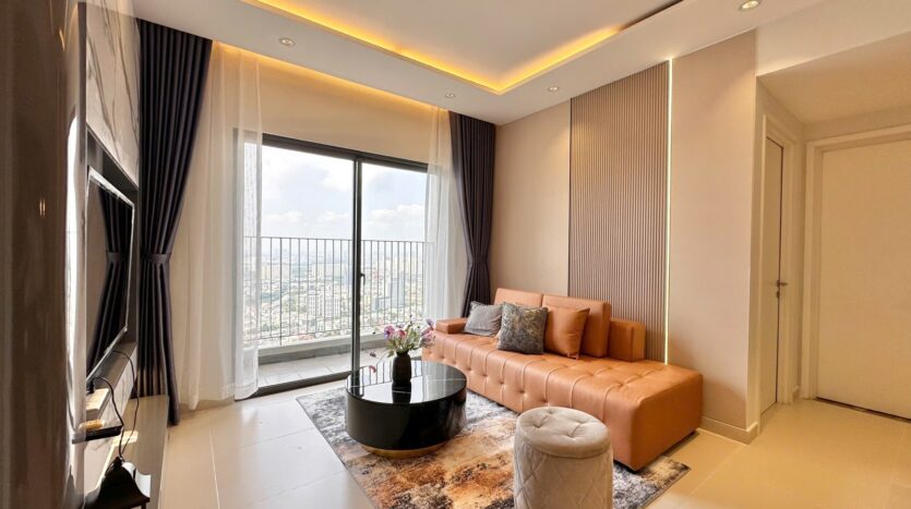 Phòng khách view ban công căn hộ Masteri Thảo Điền Tower 5 với sofa da cam | Living room with floor-to-ceiling balcony view at Masteri Thao Dien Tower 5 apartment featuring orange leather sofa