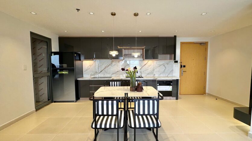 Bếp mở và bàn ăn marble căn hộ Masteri Thảo Điền với tủ bếp đen sang trọng | Open kitchen and marble dining table of Masteri Thao Dien apartment with sleek black cabinetry