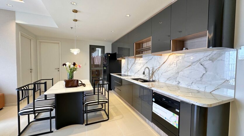 Khu bếp căn hộ Masteri Thảo Điền với tủ bếp đen và backsplash marble trắng | Kitchen area of Masteri Thao Dien apartment with black cabinetry and white marble backsplash