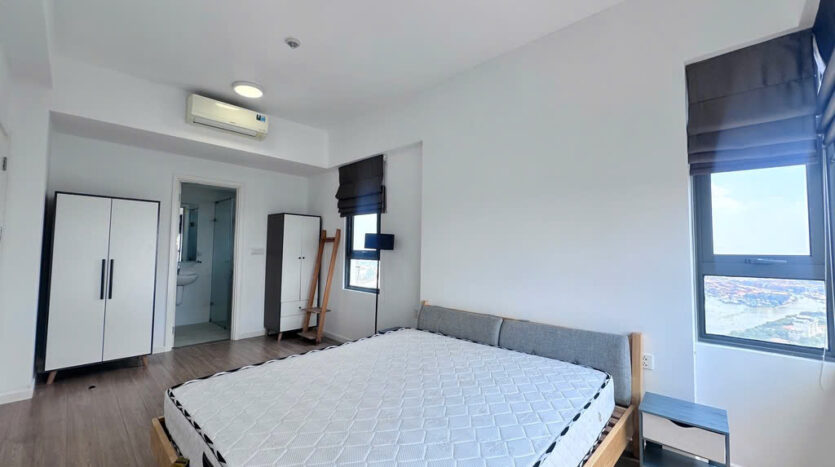 Spacious master bedroom with wood floor and built-in wardrobe at Masteri An Phu Tower B apartment