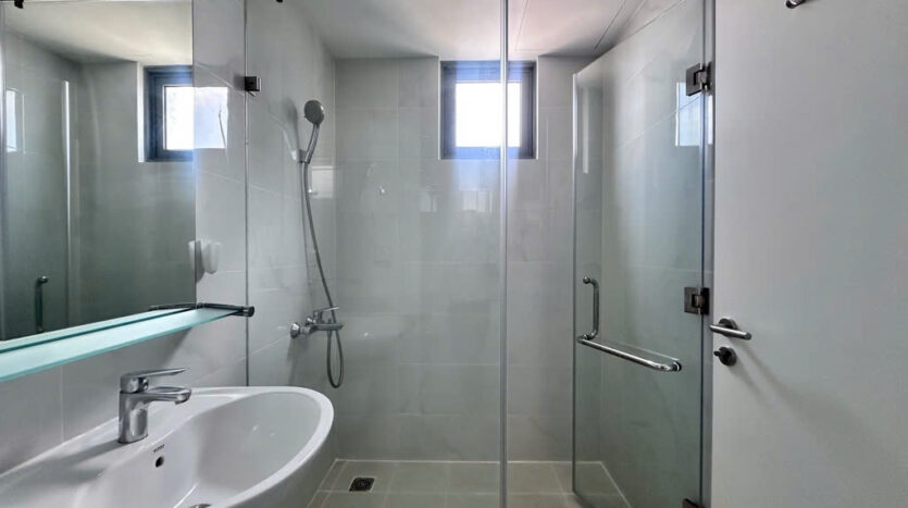 Bathroom with glass shower enclosure, marble floor and Toto fixtures at Masteri An Phu Tower B apartment