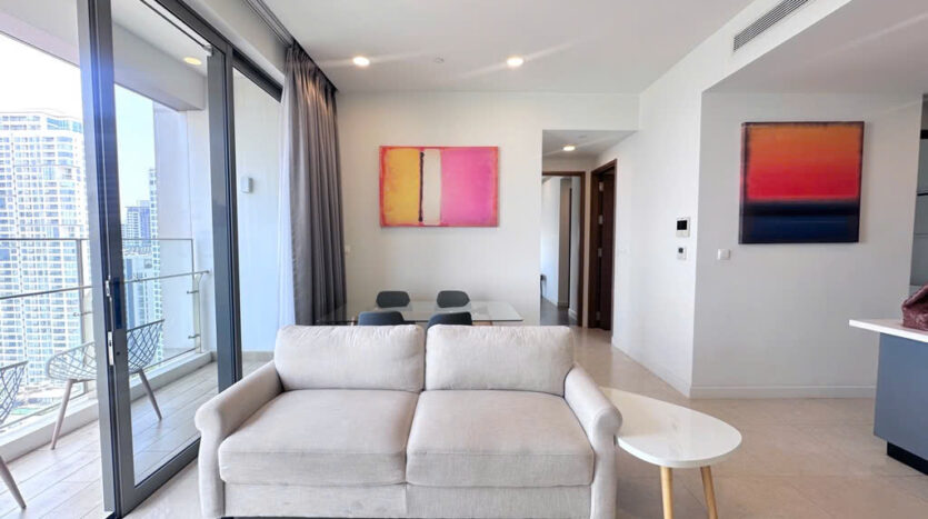 Living room with cream sofa, abstract art and balcony at The Nassim Tower A apartment