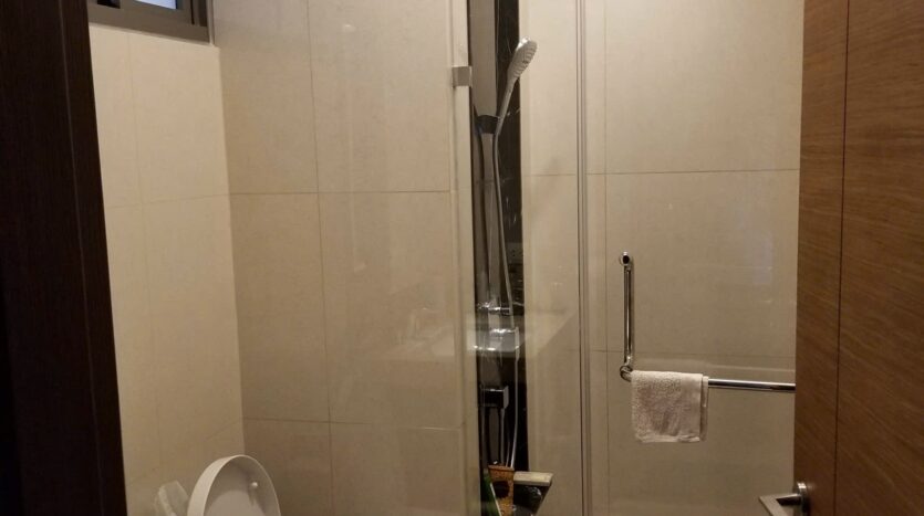 Bathroom with marble finish, glass shower and Toto fixtures at The Nassim Tower A apartment