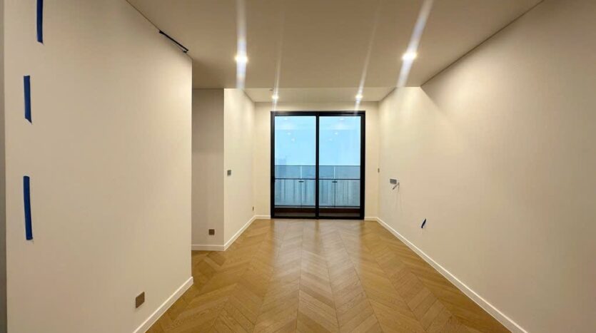 Phòng khách sàn gỗ xương cá nhìn ra ban công, căn góc Lumiere Riverside East | Living room with herringbone floor and balcony, Lumiere Riverside East corner unit